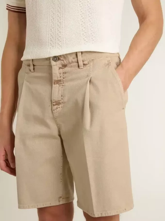 Bermudas de hombre en denim beige con acabado desgastado. Bermudas de hombre en denim beige con acabado desgastado.