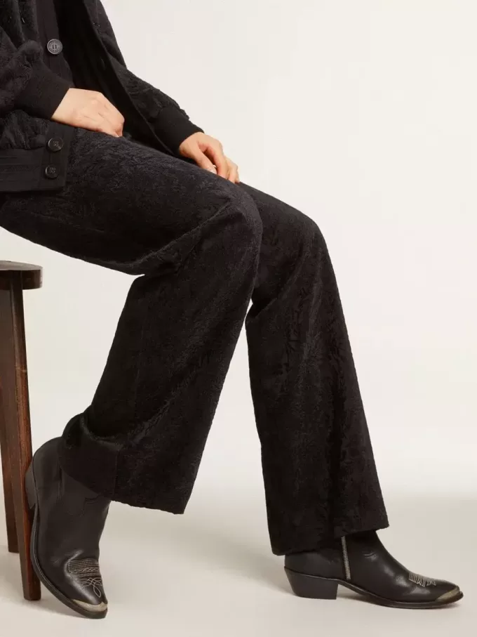 Botines juveniles de piel negra con bordados en color arena.