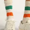 Calcetines blancos con acabado desgastado y rayas verdes y naranjas
