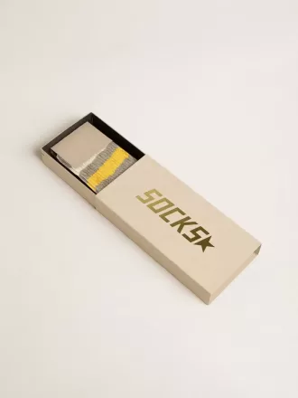 Calcetines grises con detalles desgastados y rayas amarillas y blancas