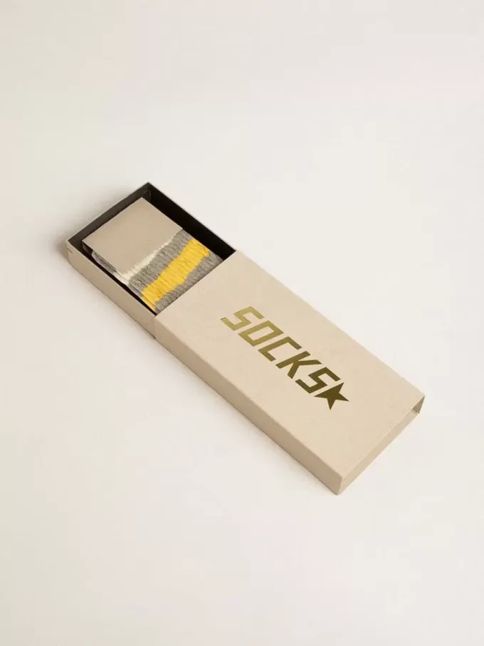 Calcetines grises con detalles desgastados y rayas amarillas y blancas