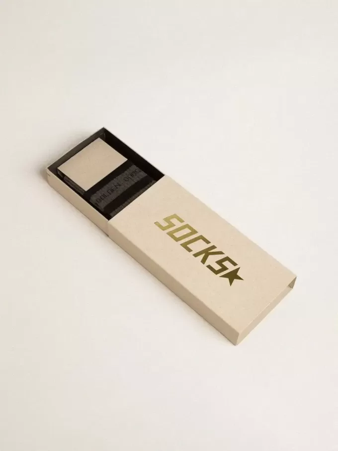 Calcetines grises con detalles desgastados y rayas negras.