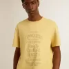 Camiseta de algodón para hombre en color amarillo pálido con letras descoloridas