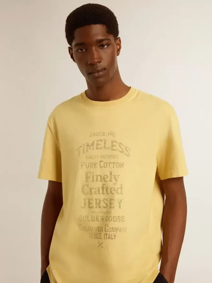 Camiseta de algodón para hombre en color amarillo pálido con letras descoloridas