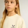 Camiseta para niña en blanco desgastado con bordado en la parte delantera y estampado en la espalda