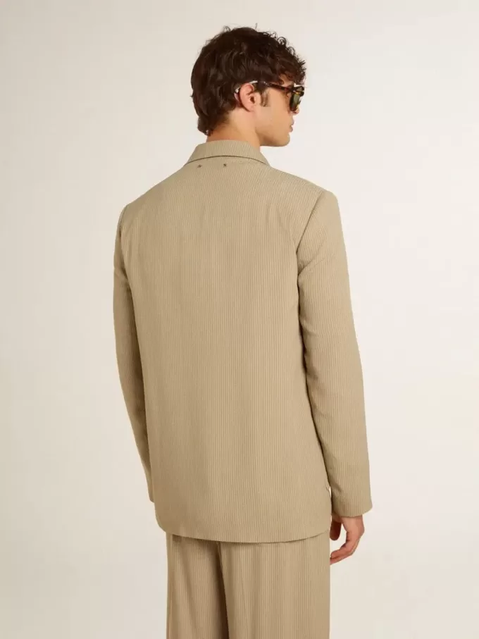 Chaqueta de hombre beige a rayas con un corte oversize y botonadura sencilla. Chaqueta de hombre beige a rayas con un corte oversize y botonadura sencilla.