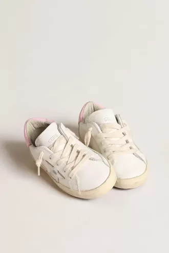 Junior Super-Star en piel blanca con estrella metálica plateada y lengüeta rosa en el talón