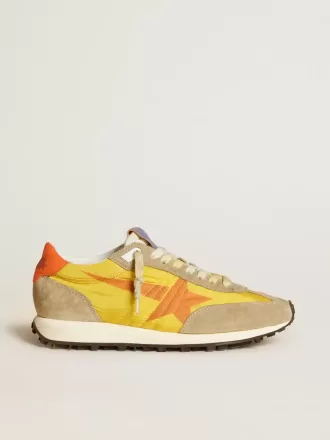 Marathon para mujer con parte superior de nailon amarillo y estrella naranja.