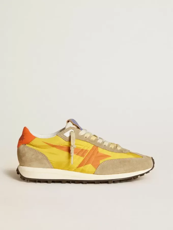 Marathon para mujer con parte superior de nailon amarillo y estrella naranja.