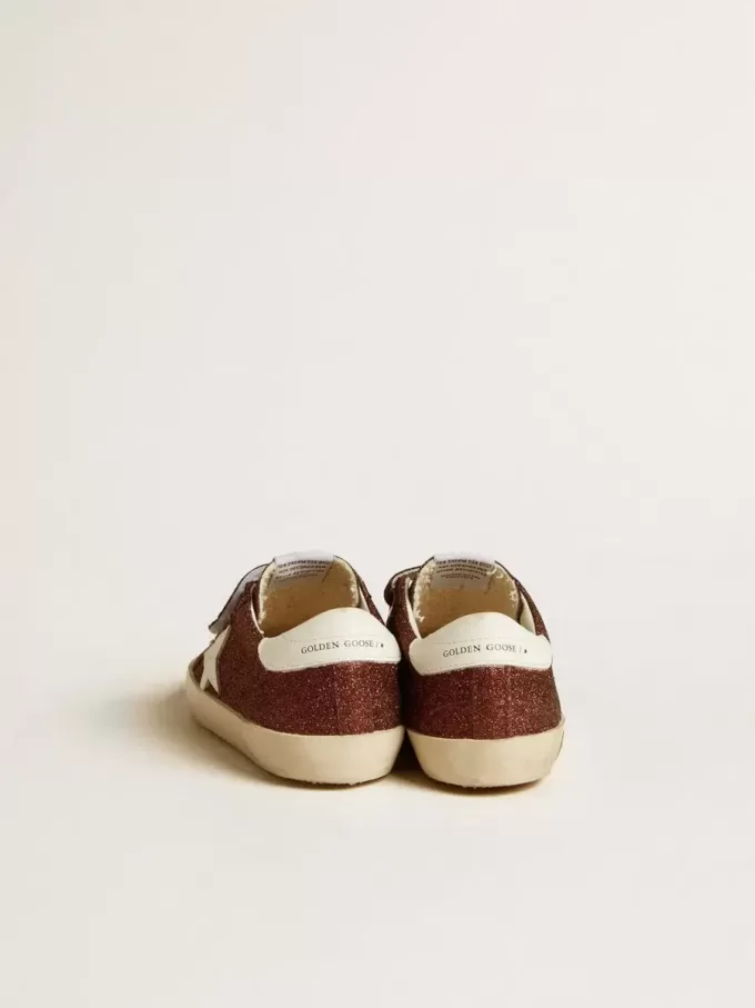 Old School Junior en color burdeos brillante con estrella y lengüeta en el talón de cuero. Old School Junior en color burdeos brillante con estrella y lengüeta en el talón de cuero.