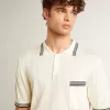 Polo de punto blanco desgastado para hombre con ribetes azules
