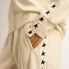 Sudadera blanca con cremallera para mujer con franja blanca y estrellas negras