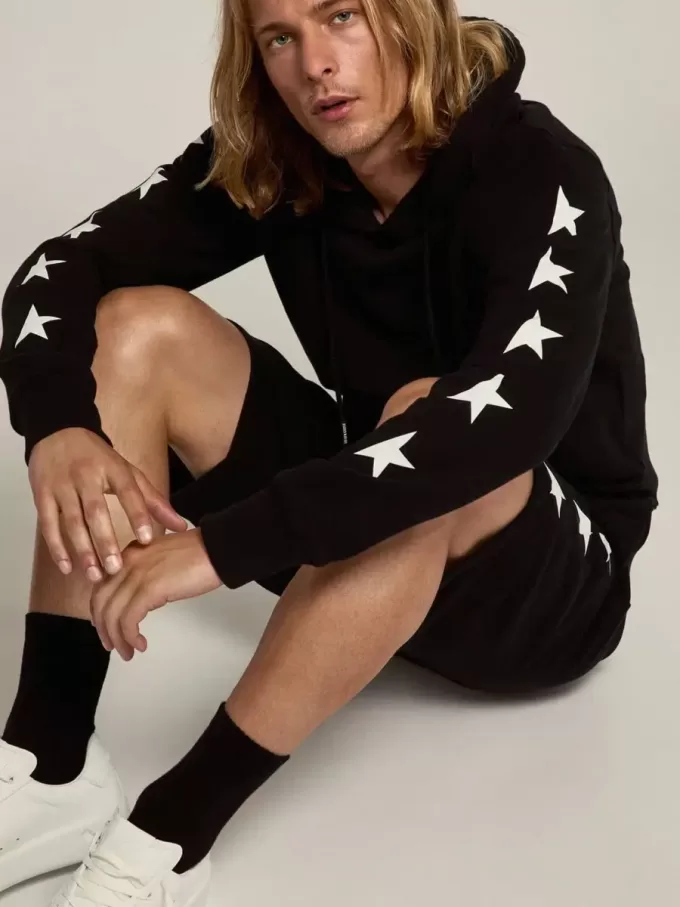 Sudadera negra de la colección Alighiero Star con estrellas blancas en contraste.