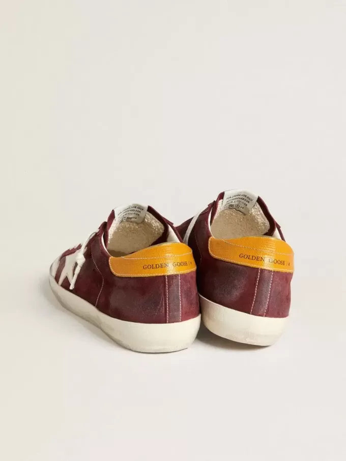 Super-Star para hombre en ante rojo ladrillo con estrella de cuero blanco y lengüeta del talón con estampado animal.