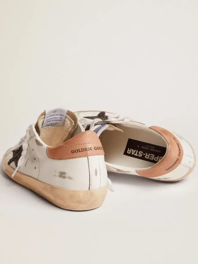 Super-Star para mujer con estrella negra brillante y lengüeta rosa en el talón Super-Star para mujer con estrella negra brillante y lengüeta rosa en el talón