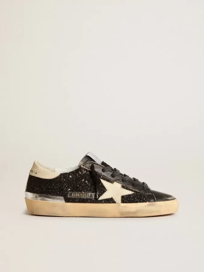 Super-Star para mujer en negro brillante y napa con estrella y lengüeta del talón en piel color crema.