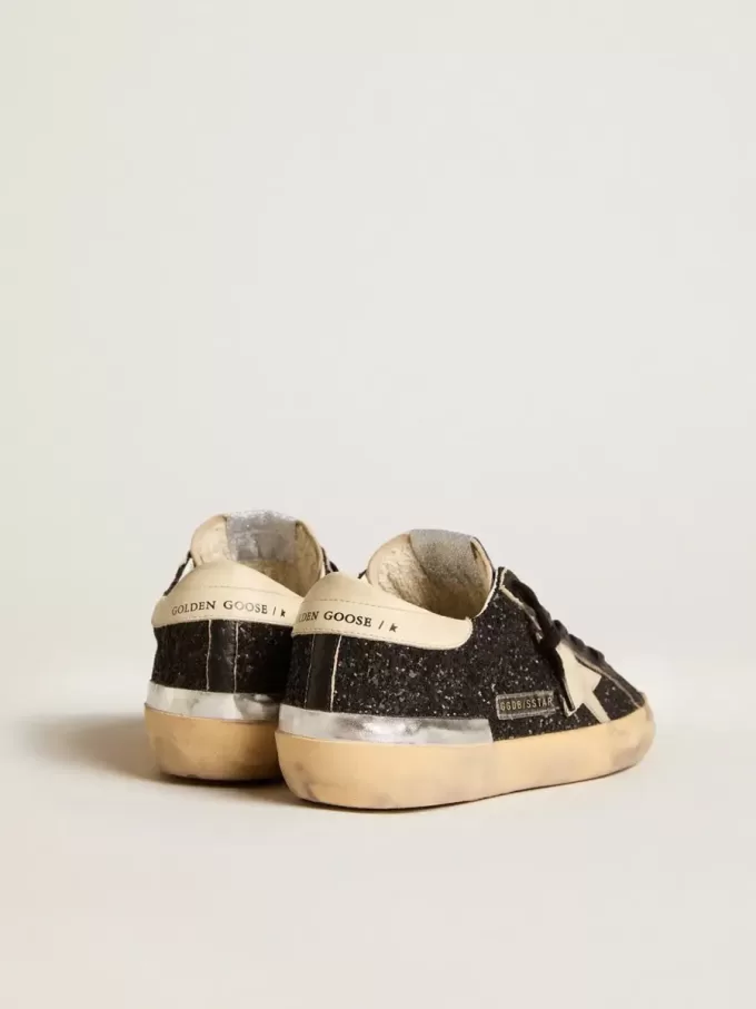 Super-Star para mujer en negro brillante y napa con estrella y lengüeta del talón en piel color crema.