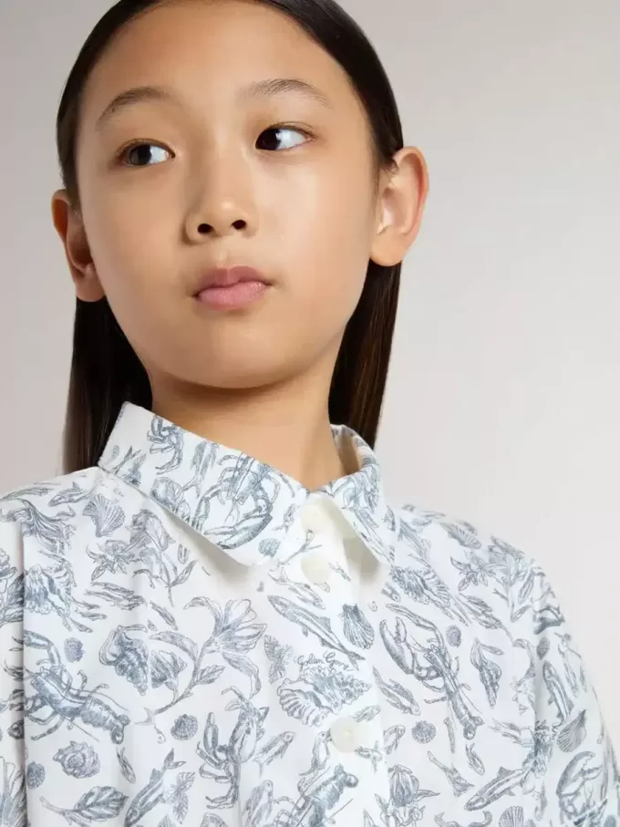 Vestido camisero para niña en lona de algodón blanca con estampado náutico azul y ribetes blancos