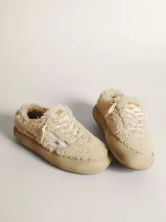 Zapatos Space-Star para mujer en piel de oveja beige con estrella de piel blanca y lengüeta metálica en el talón.